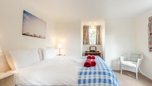 A hotel room with a bed, a desk, a chair, a lamp, and a painting on the wall. - 4 Bed in Old Hunstanton (oc-kt169) (Hunstanton)
