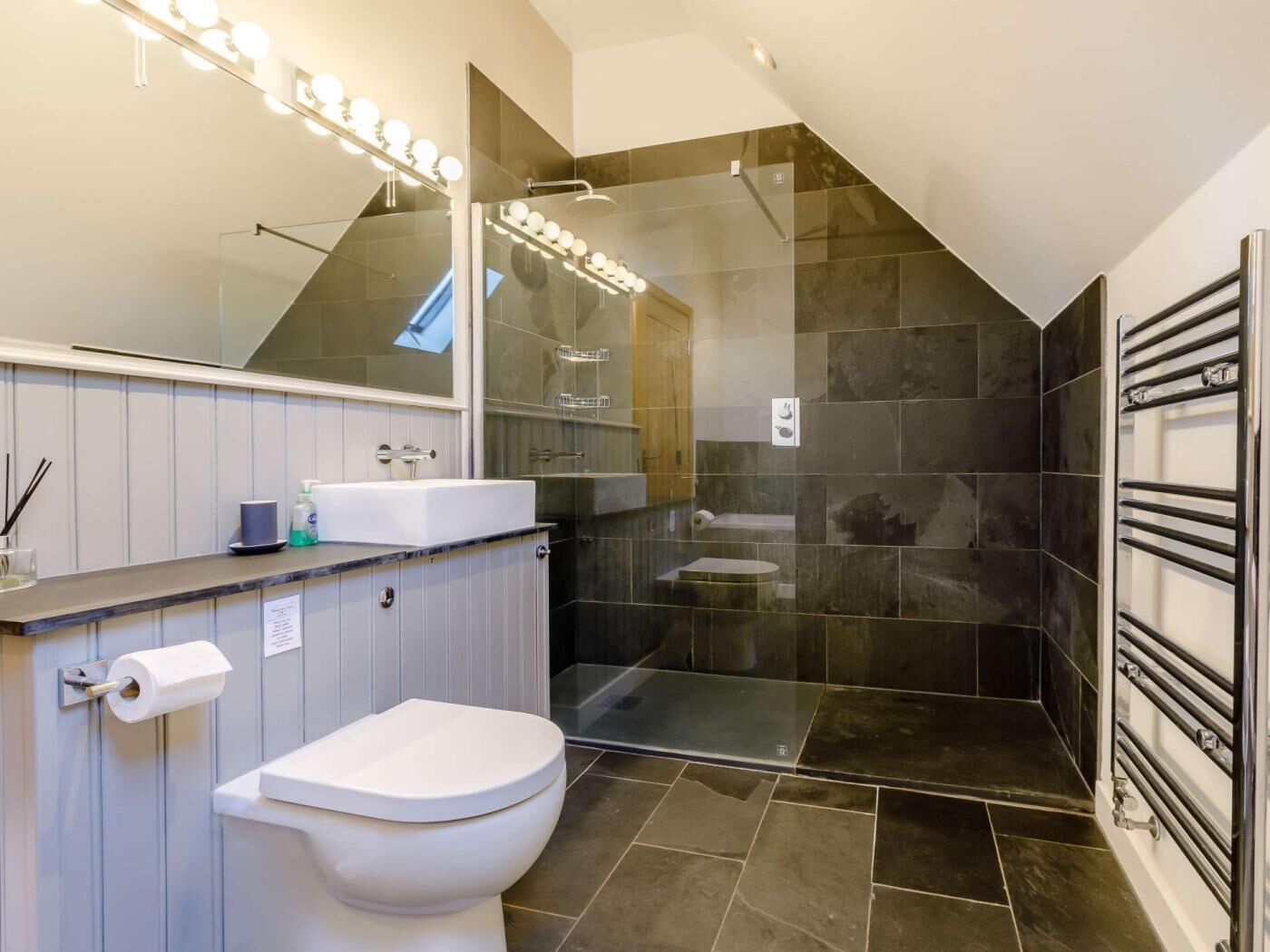 Un baño moderno con ducha, inodoro y tocador.