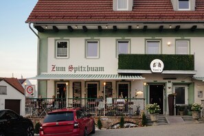 Un edificio con fachada verde, un letrero que dice 'Zum Spitzbuam' y un letrero más pequeño para 'Balkan Grillhaus'.