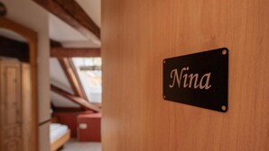 A door with a sign that reads 'Nina' on a wooden door.