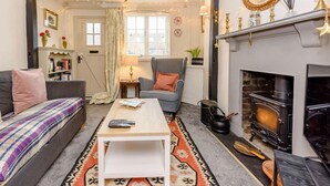 A cozy living room with a fireplace, a sofa, a coffee table, and a television. - 1 Bed in Tenterden (oc-66342) (Tenterden)