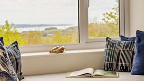 A window seat with a view of a body of water, a book, and binoculars. - 2 Bed in Bangor (oc-66276) (Llanddeiniolen)