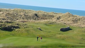 Un campo de golf con vistas al océano.