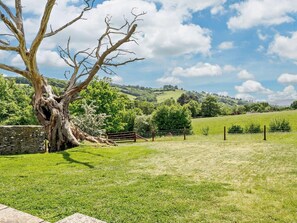 A rural landscape with a large tree, stone wall, and a fenced field. - 2 Bed in Abergavenny (oc-66630) (Dorstone)