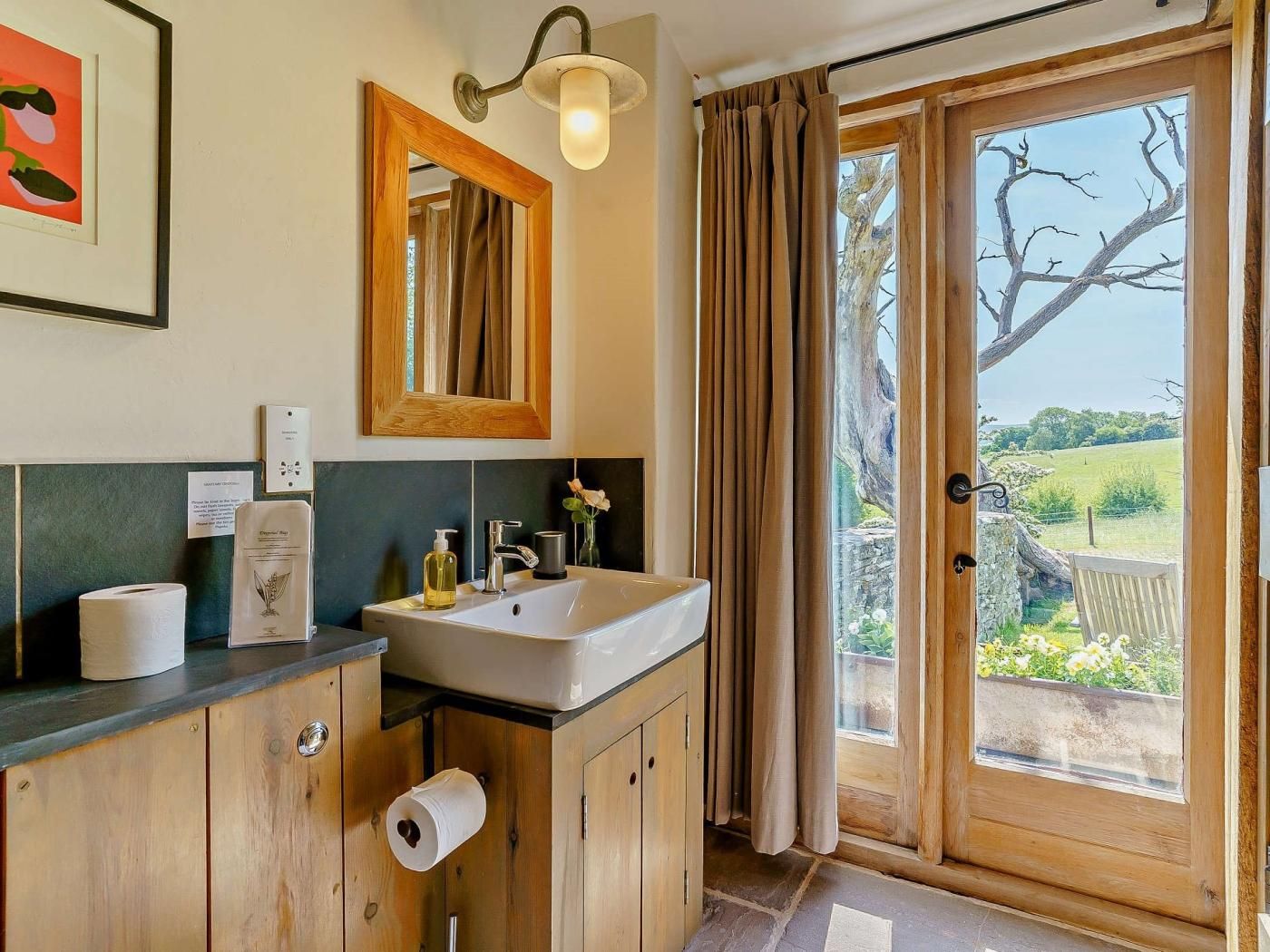 Une salle de bain avec un lavabo, un miroir et du papier toilette.