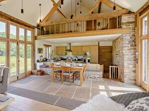 A spacious loft-style living area with a dining table, kitchen, and large windows. - 2 Bed in Abergavenny (oc-66630) (Dorstone)