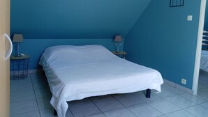 Une chambre à coucher avec un lit, deux tables de chevet et un tableau accroché au mur.