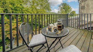 En balkong med ett bord, stolar och en plats för att dricka kaffe.