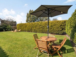 A patio with a table and chairs, an umbrella, and a hedge in the background. - 2 Bed in Louth (oc-72401) (Fotherby)