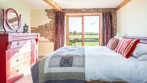 A bedroom with a bed, dresser, and a view of the countryside through a large window. - 4 Bed in Gillingham (oc-80670) (West Stour)