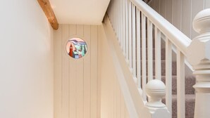 A staircase with white balusters and a wooden handrail, leading to a landing with a circular stained glass window. - 4 Bed in Gillingham (oc-80670) (West Stour)