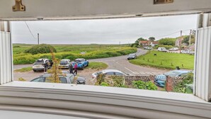 A rural road with parked cars and a few people walking. - 2 Bed in Holt (oc-ncc15) (Salthouse)