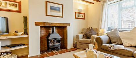 A cozy living room with a fireplace, a television, and a comfortable seating area.