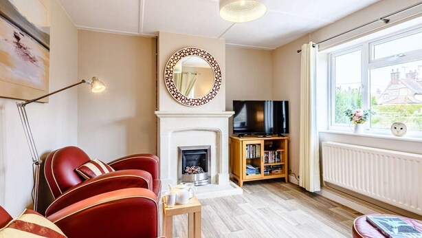 Ein Wohnzimmer mit Kamin, Fernseher und Bücherregal.