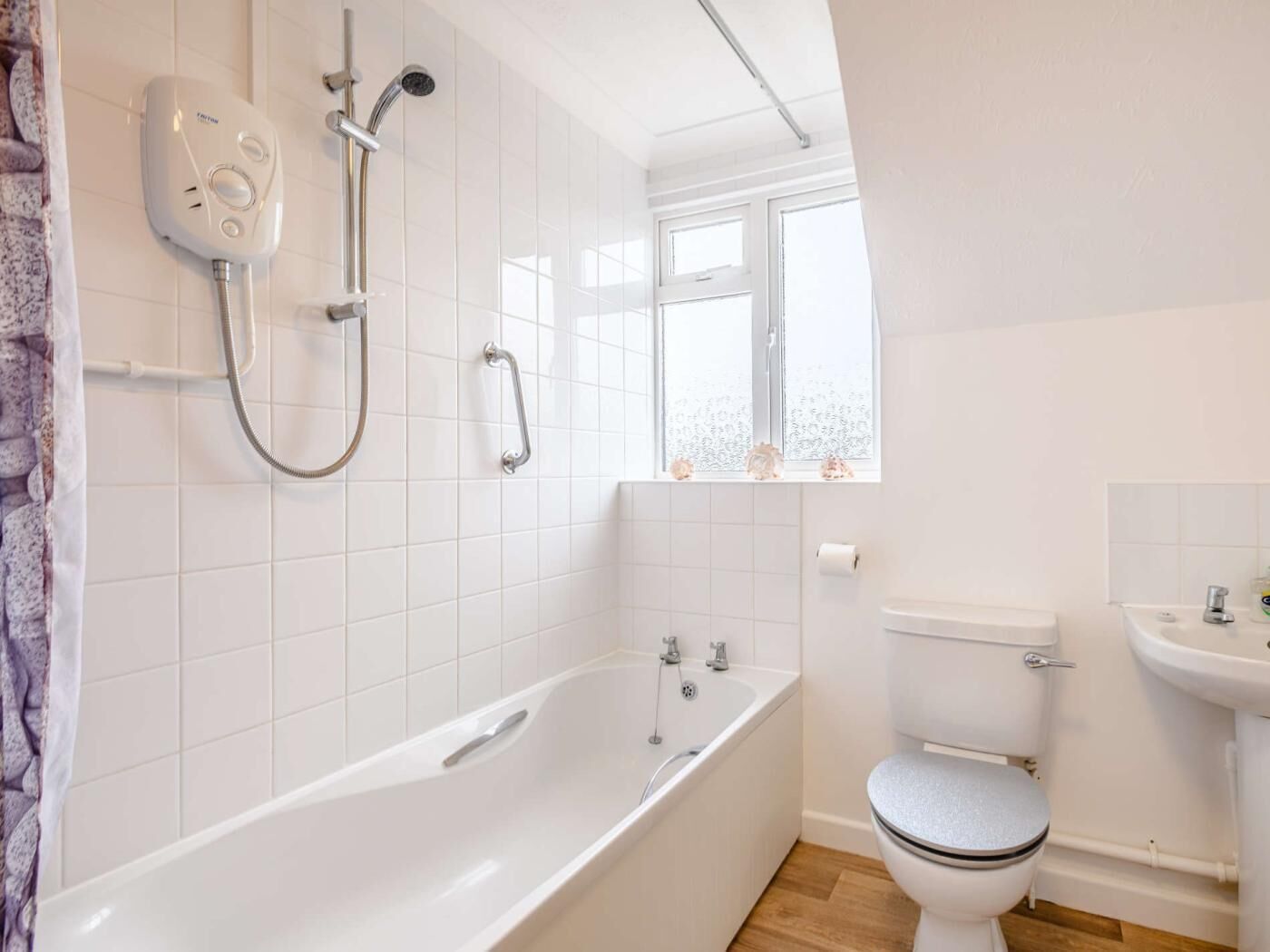 A bathroom with a bathtub, toilet, and shower.