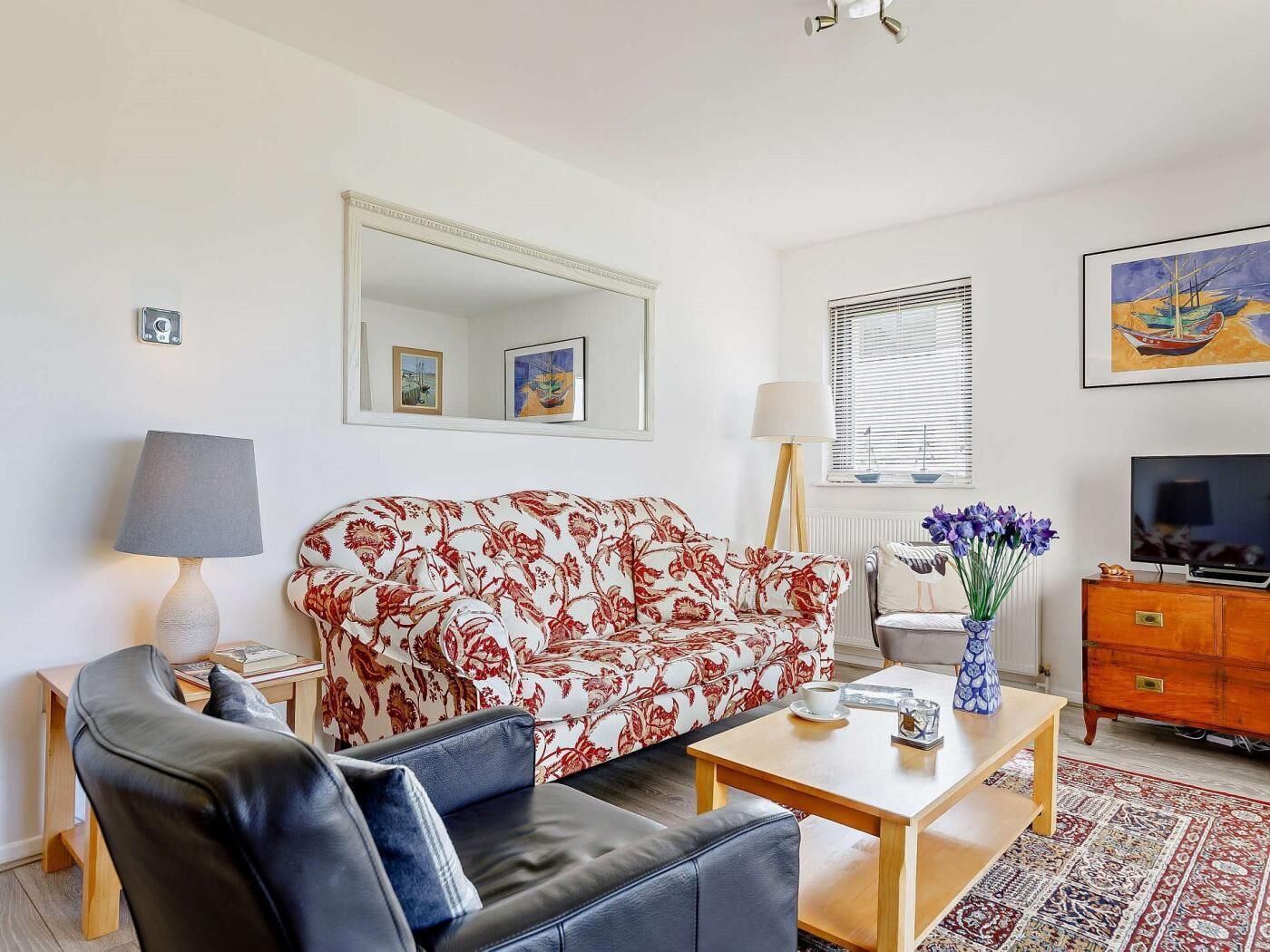 A living room with a sofa, a coffee table, a TV, and a lamp.
