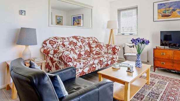 A living room with a sofa, a coffee table, a TV, and a lamp. - 2 Bed in Bideford (oc-73433) (Instow)