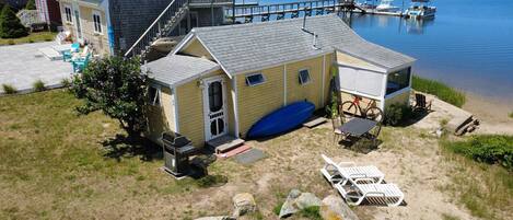 A waterfront property with a covered patio, outdoor seating, and a dock.