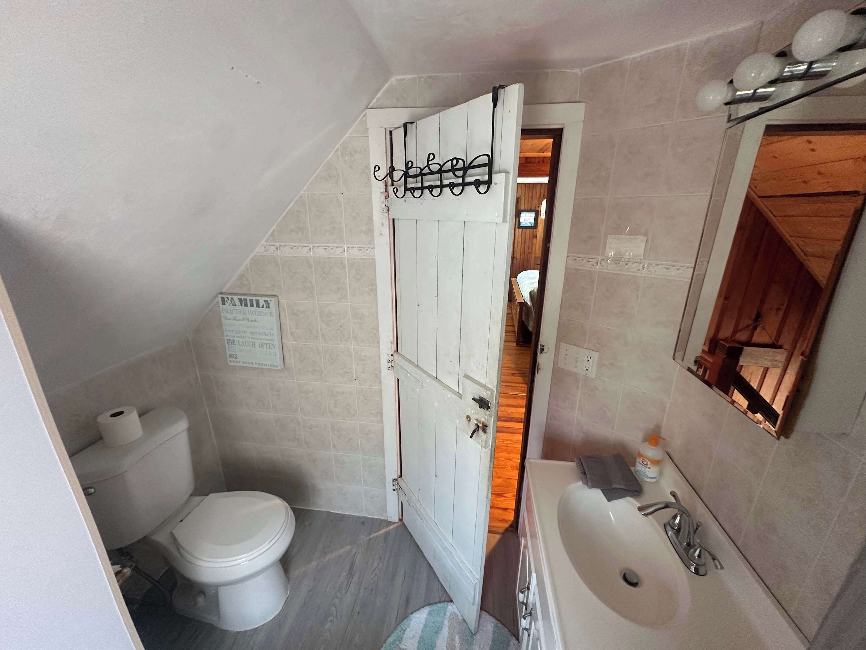Ein kleines Badezimmer mit Toilette, Waschbecken und Spiegel.