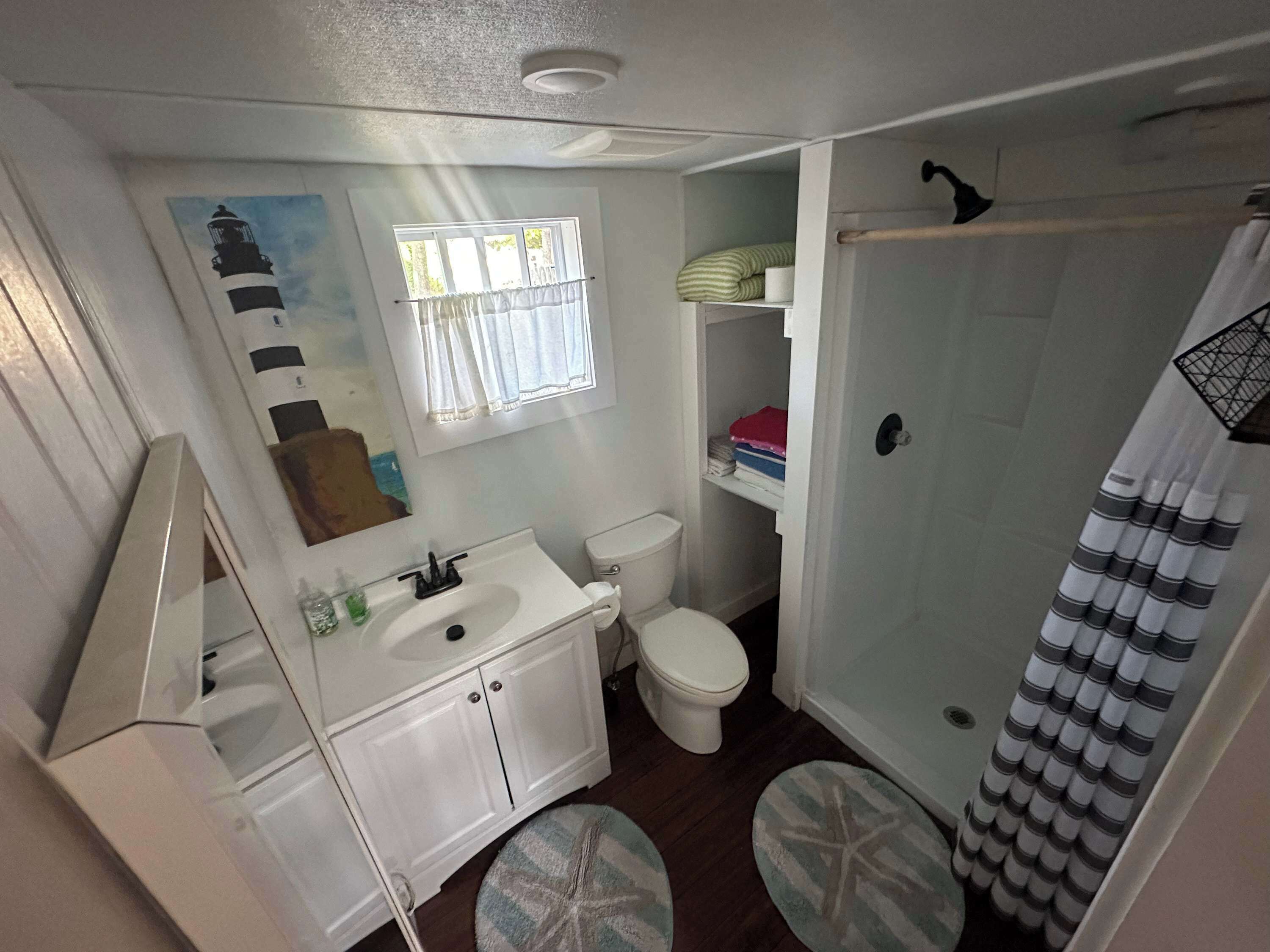 Une petite salle de bain comprenant des toilettes, un lavabo et un espace douche.