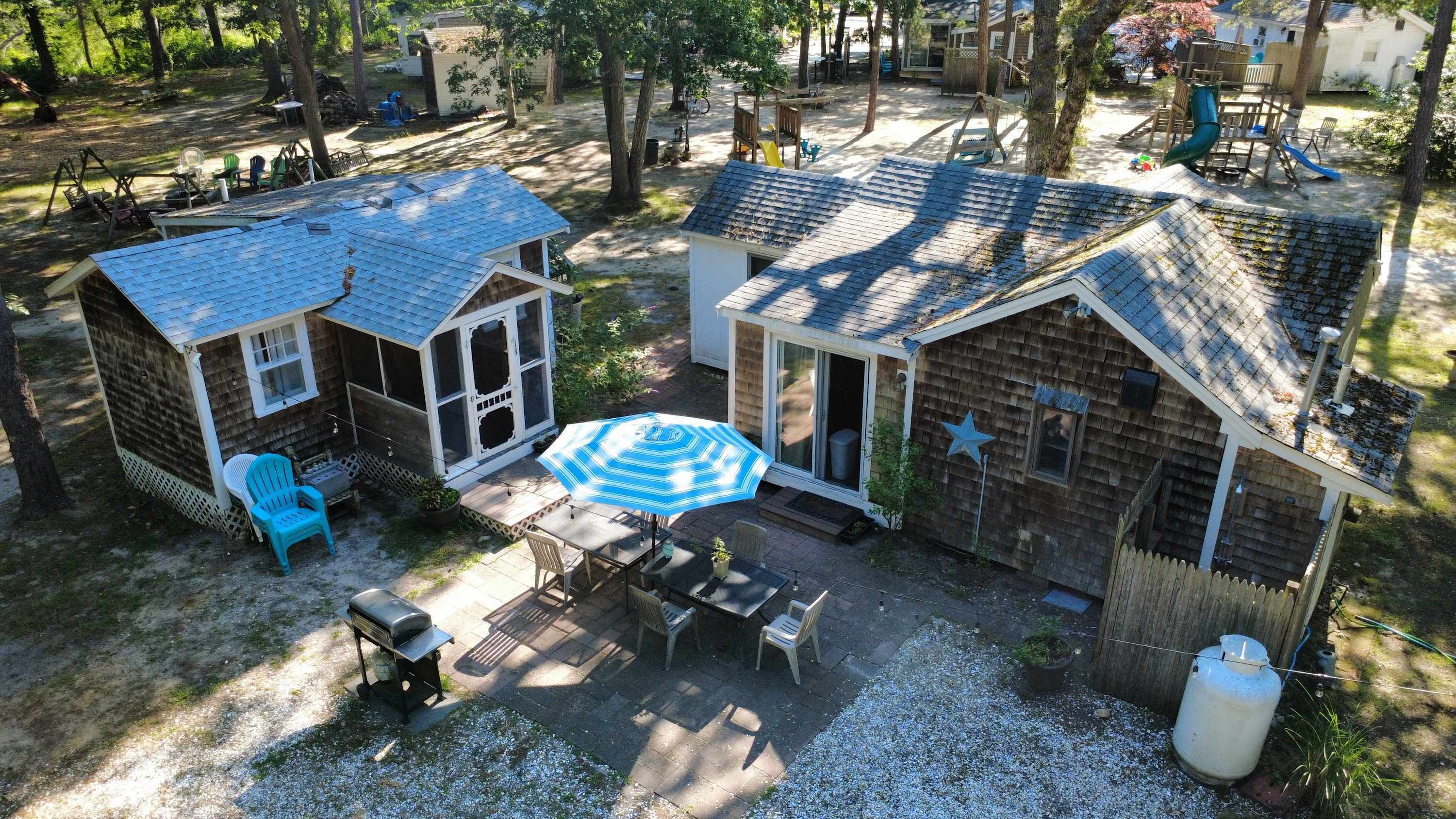 A residential property with a patio area, outdoor seating, and a small play structure.