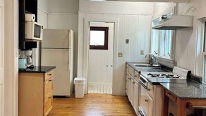 A kitchen with wooden cabinets, a stove, and a microwave.