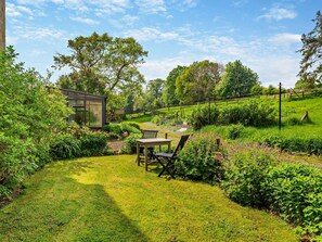 A garden with a table and chairs, a greenhouse, and a pond. - 1 Bed in Richmond (oc-g0025) (Moulton)