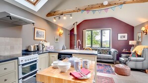 Una cucina moderna con un lucernario, un'area pranzo con divano e vista sull'esterno.
