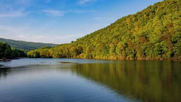 A calm lake surrounded by forested hills.