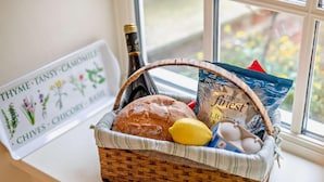 A wicker basket on a windowsill containing bread, a lemon, eggs, and a bottle of wine. - 1 Bed in York (oc-g0032) (Crayke)
