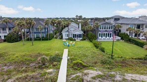 A residential area with houses, a pathway, and a lawn. - Baba's Beach House - Oceanfront Family Cottage (Jacksonville Beach)