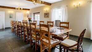 A dining area with a long wooden table, multiple chairs, a chandelier, and wall sconces. - 8 Bed in Cockermouth (oc-82453) (Blindcrake)