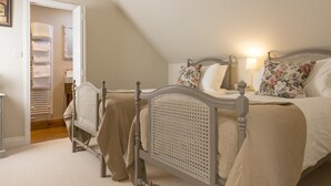 Un dormitorio con dos camas individuales, un vestidor y un techo inclinado.