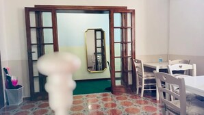 A room with a dining table and chairs, a mirror, and a green carpet. - Villa Matilde (Pisa)