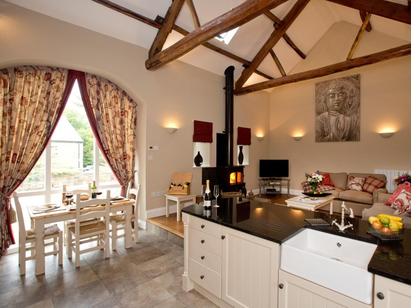 A cozy living room with a fireplace, a dining area with a table and chairs, and a kitchen with a large island.