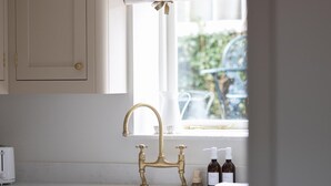 A kitchen with a brass faucet, a window with a view of greenery, and a toaster on the counter. - 1 Bed in Sedbergh (oc-g0182) (Millthrop)
