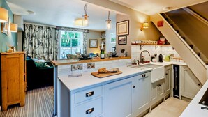 A modern kitchen with a central island, pendant lighting, and a view of the outdoors. - 1 Bed in Pickering (oc-g0120) (Rosedale Abbey)