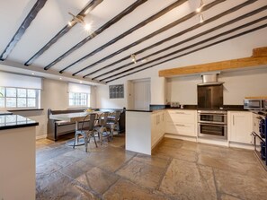 A modern kitchen with exposed beams, stone flooring, and built-in appliances. - 6 Bed in Richmond (oc-g0178) (Gilling West)