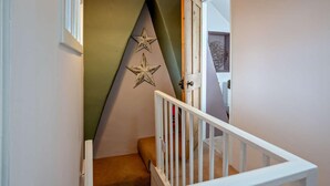 Eine Treppe mit weißer Geländer, einer grünen Wand und zwei Sterndekorationen.