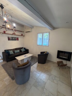 A living room with a sofa, coffee table, and a TV. - "Gege's Cottage" House with a garden and a pool (Vence)