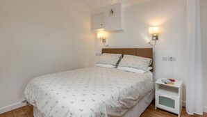Ein Schlafzimmer mit einem Bett, Nachttischen und Wandleuchten.