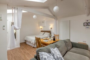Ein Schlafzimmer mit Bett, Nachttisch und einem Vorhangfenster.