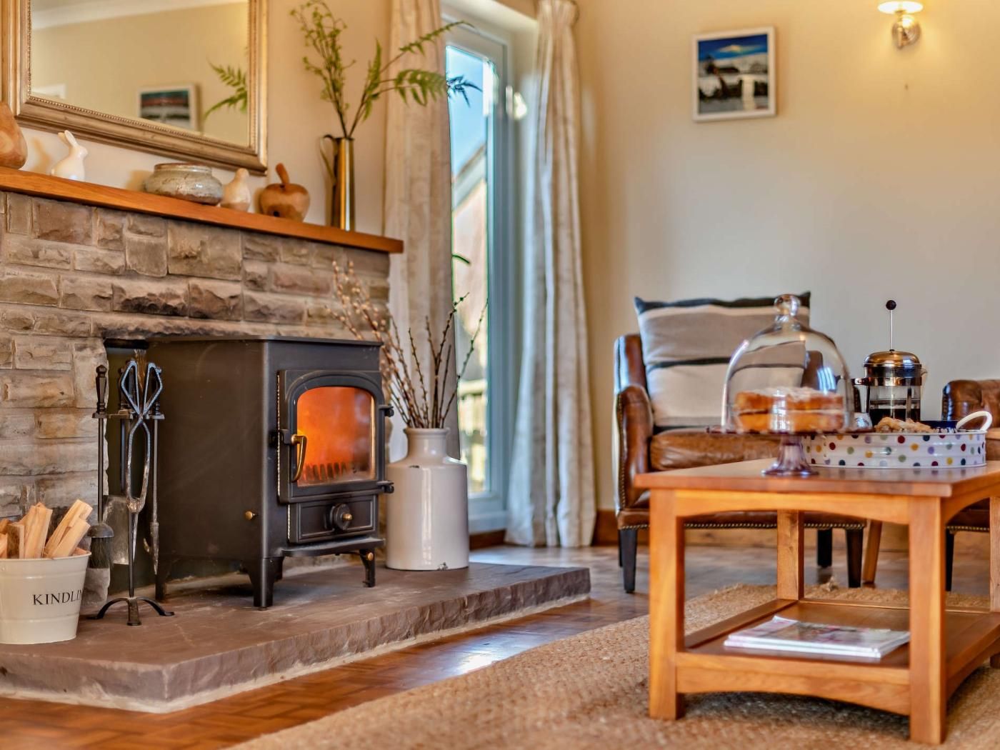 A cozy living room with a stone fireplace, a wooden coffee table, and a comfortable seating area.