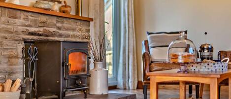 A cozy living room with a stone fireplace, a wooden coffee table, and a comfortable seating area.
