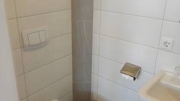 Un baño con inodoro, lavamanos y dispensador de toallas.