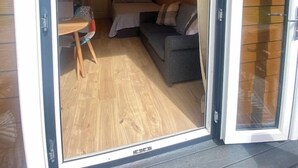 Quarto compacto com cama, sofá e uma pequena mesa.