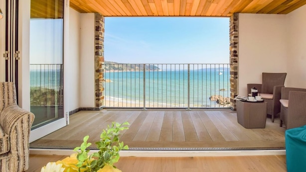 A balcony with a wooden ceiling, a view of the sea, and outdoor furniture. - 3 Bed in Torpoint (oc-74300) (Kingsand)