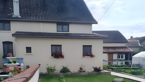 A residential building with a sloped roof, a well-maintained lawn, and flower boxes on the windowsills.