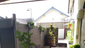 A patio area with a table, chairs, a sofa, and potted plants.