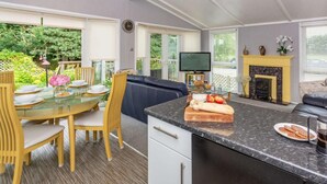 Eine moderne Küche mit Essbereich, Kamin und Fernseher.